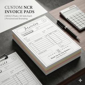Puede incluir: Una pila de blocs de facturas NCR personalizados con un diseño en blanco y negro. Los blocs tienen un fondo blanco con texto y líneas negras para rellenar los detalles de la factura. También se ve una calculadora y un bolígrafo.