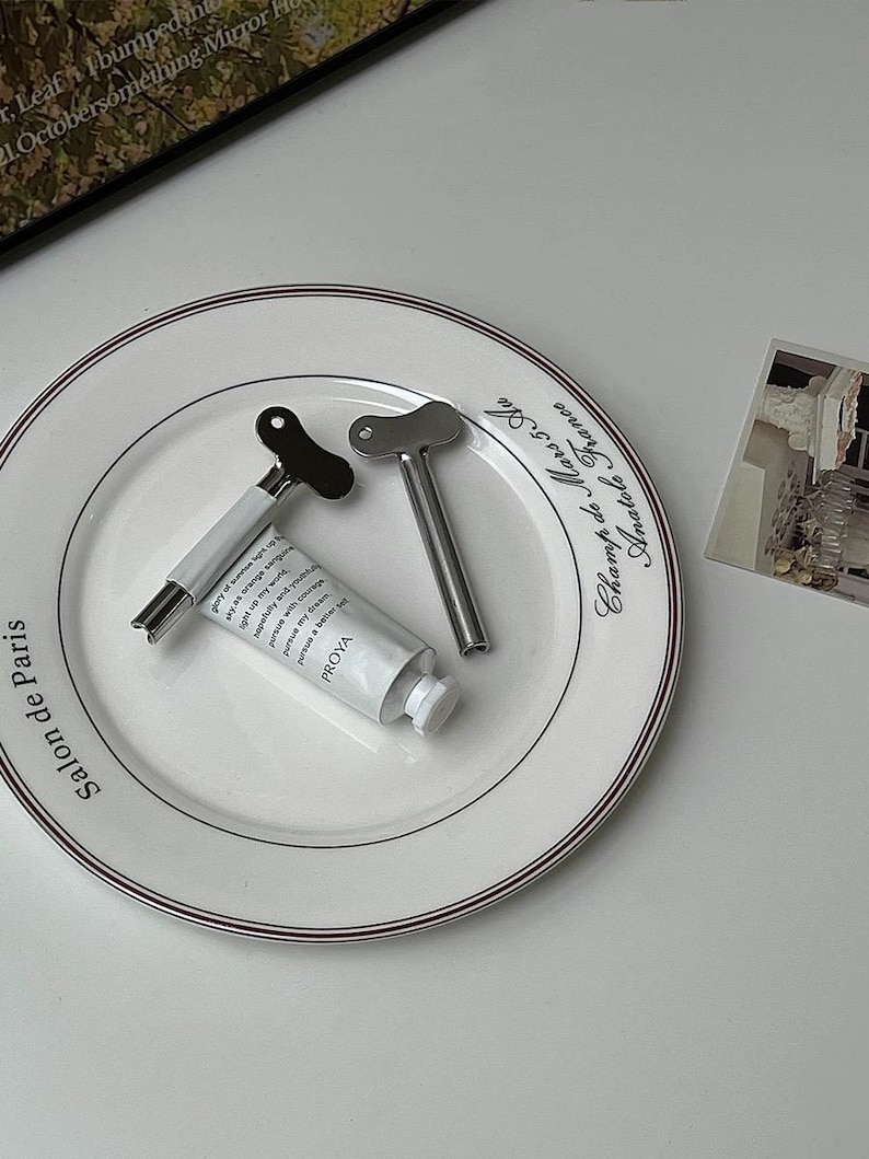 Pu&ograve; includere: Una tazza di ceramica bianca con un manico nero e la scritta "But First, Coffee" in stile scritto a mano. La tazza &egrave; su una superficie bianca. La tazza &egrave; probabilmente per bevande calde.