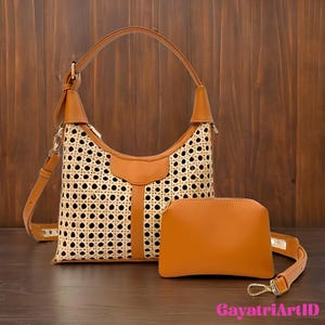 May include: A tan shoulder bag with a woven rattan front panel and a matching small pouch. The bag has a brown leather handle and trim. The small pouch has a detachable strap. The bag is set against a brown wooden background.
