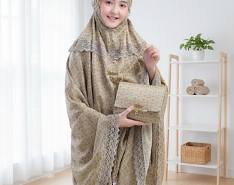 May include: A woman wearing a matching beige prayer garment and head covering, holding a beige handbag with a gold chain strap. The outfit features a floral pattern and lace trim. The image includes the text "GayatriArtID".