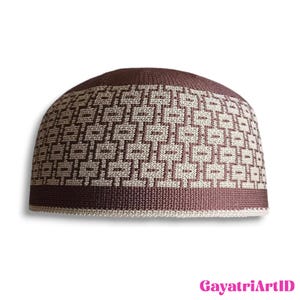 May include: A brown and beige kufi hat with a geometric pattern. The hat features a repeating square design in a lighter beige colour against a darker brown background. The brim is a solid brown colour. The text "GayatriArtID" is in the bottom right corner.