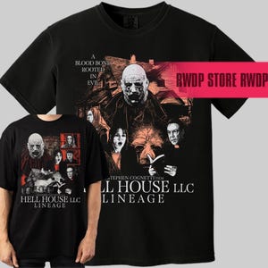 May include: Black t-shirts featuring a horror movie graphic. The design includes a bald man, a house, and the text "A BLOOD BOND ROOTED IN EVIL." The text "HELL HOUSE LLC LINEAGE" is also visible.