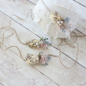 K&ouml;nnte beinhalten: Zwei zarte Blumen-Stirnb&auml;nder mit Seestern-Akzenten und Perlenbesatz. Die Stirnb&auml;nder sind mit Schnur gebunden und perfekt f&uuml;r ein Neugeborenen- oder Babyshooting.