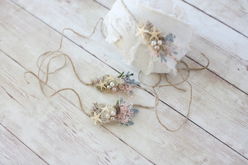 K&ouml;nnte beinhalten: Zwei zarte Blumen-Stirnb&auml;nder mit Seestern-Akzenten und Perlenbesatz. Die Stirnb&auml;nder sind mit Schnur gebunden und perfekt f&uuml;r ein Neugeborenen- oder Babyshooting.