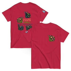 May include: Red t-shirt featuring a snail graphic on the front pocket and a larger design on the back. The back design includes multiple snails and the text "MY GI TRACT IS SLOW AS SHELL Dysmotility Awareness". A blue ribbon is also present.