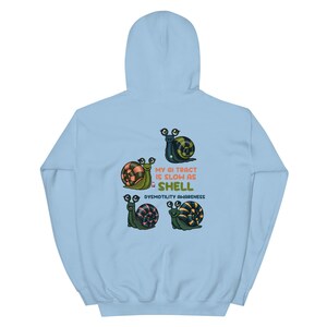 May include: Light blue hoodie featuring four cartoon snails with various shell patterns. The text "MY GI TRACT IS SLOW AS SHELL" and "DYSMOTILITY AWARENESS" are printed on the hoodie.