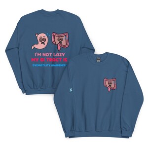 May include: Blue sweatshirt with a pink stomach and colon graphic, and the text "I'M NOT LAZY MY GI TRACT IS DYSMOTILITY AWARENESS". The sweatshirt also features a small ribbon and a colon graphic on the front.