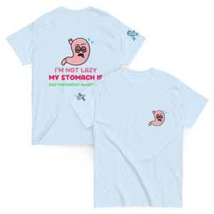May include: Light blue t-shirts with a cartoon stomach design. One shirt has a large graphic on the back with the text "I'M NOT LAZY MY STOMACH IS GASTROPARESIS AWARE". The other shirt has a smaller stomach graphic on the front.
