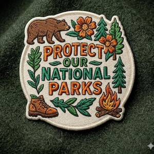 May include: Embroidered patch with the text "PROTECT OUR NATIONAL PARKS". The patch features a brown bear, orange flowers, green trees, a hiking boot, and a campfire. The patch is on a green fabric background.