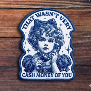May include: A blue and white patch featuring a vintage illustration of a girl holding a telephone. The text on the patch reads "THAT WASN'T VERY CASH MONEY OF YOU."