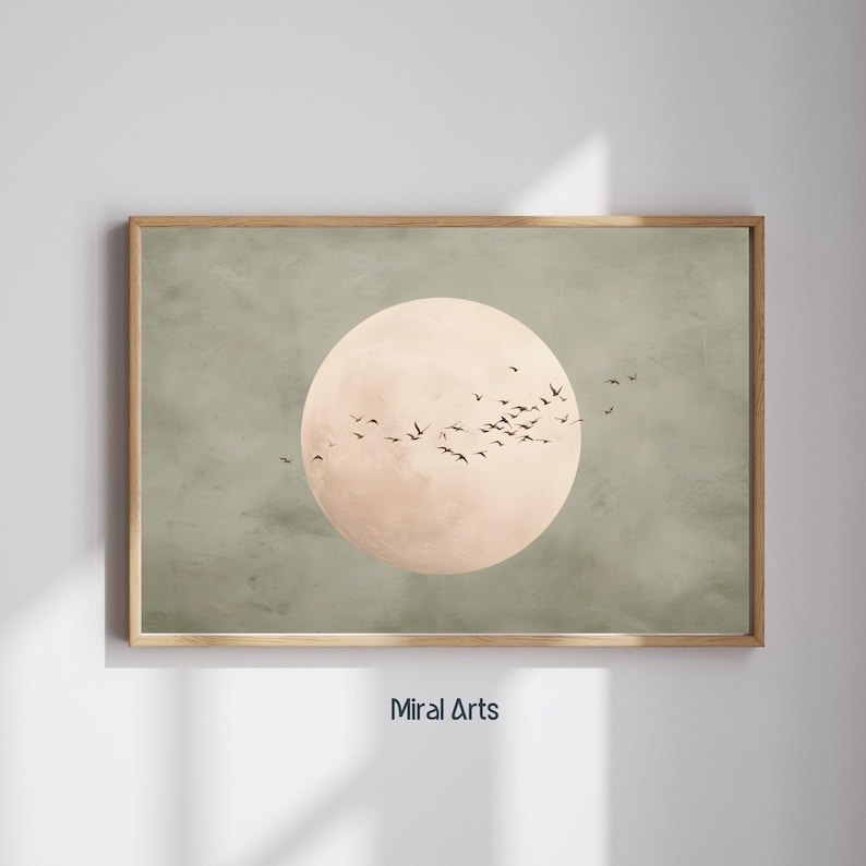May include: A framed art print featuring a large, pale peach-colored circle, possibly representing the sun or moon, against a muted green background. Silhouettes of birds fly across the circle. The text "Miral Arts" is at the bottom.