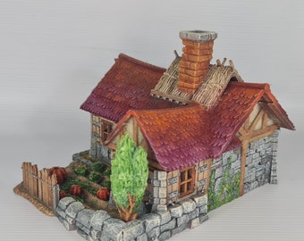 May include: A miniature stone cottage with a red tile roof, a chimney, and a small garden. The cottage has a wooden door and windows. A small wooden fence surrounds the garden, which contains pumpkins and other plants.