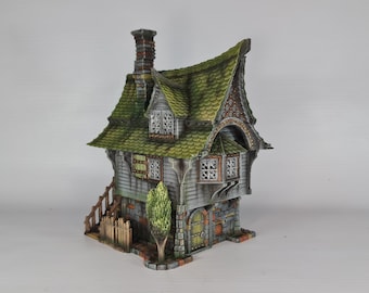 May include: A miniature model of a two-story house with a green roof, stone walls, and a small tree in front. The house has a chimney and a door with a stone archway. The model is painted in realistic detail.