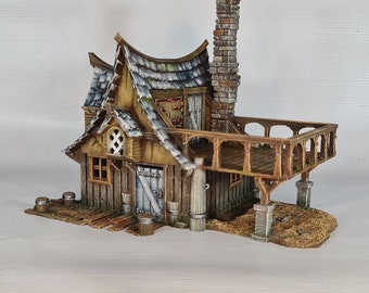 May include: A miniature, weathered wooden cottage with a stone chimney and a small balcony. The cottage features a gray shingled roof, wooden doors, and windows. Barrels and other small details add to the rustic charm of this model.