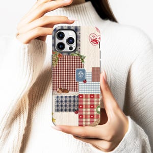 May include: A patchwork phone case with a mix of patterns such as gingham, stars, and floral motifs. The case uses a colour scheme of red, blue, and cream, with heart and ladybug details. The case is designed for a smartphone.
