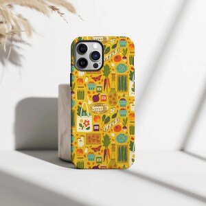 Puede incluir: Funda de teléfono amarilla con un patrón repetido de ilustraciones de alimentos, incluyendo verduras, pan y mariposas. La funda tiene un acabado brillante y un recorte para la cámara. El diseño utiliza colores naranja, verde y marrón.