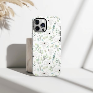Könnte beinhalten: Weißes Handycase mit einem sich wiederholenden Muster aus Koalas und grünem Laub. Die Koalas sind im Cartoon-Stil dargestellt, und die Blätter sind in Grün- und Blautönen gehalten. Das Case hat eine schwarze Kameralinse.