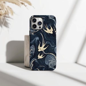 Könnte beinhalten: Marineblaue Handyhülle mit einem Wirbelmuster und goldenen Schwalbenillustrationen. Die Hülle hat eine glänzende Oberfläche und ein schützendes Design. Die Schwalben sind im Flug dargestellt und verleihen dem Accessoire einen Hauch von Eleganz.