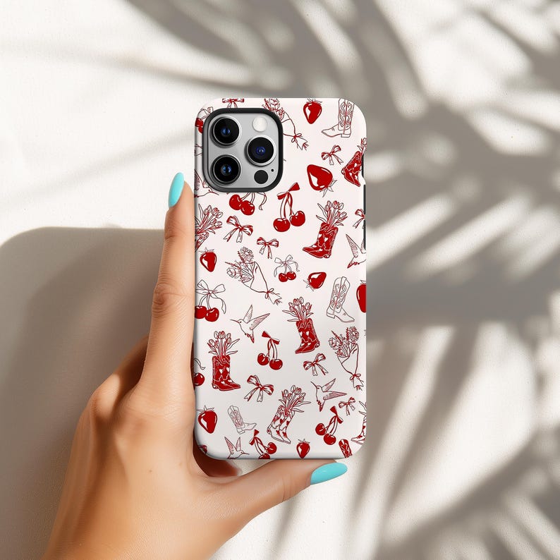 Pu&ograve; includere: Custodia per telefono bianca con un motivo rosso ripetuto di stivali da cowboy, ciliegie, bouquet, fiocchi e fragole. La custodia ha una finitura lucida e un ritaglio per la fotocamera.