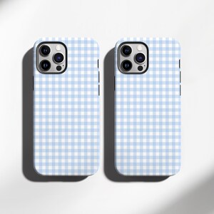 May include: Two phone cases with a light blue and white gingham pattern. The cases have a camera cutout and a black border. The cases are on a white background with a shadow.