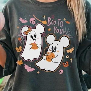 May include: Dark gray t-shirt featuring a Halloween design. The shirt displays two cartoon ghost characters holding pumpkins, with the text "Boo To You" above them. The design includes bats, spiderwebs, and other Halloween-themed graphics.