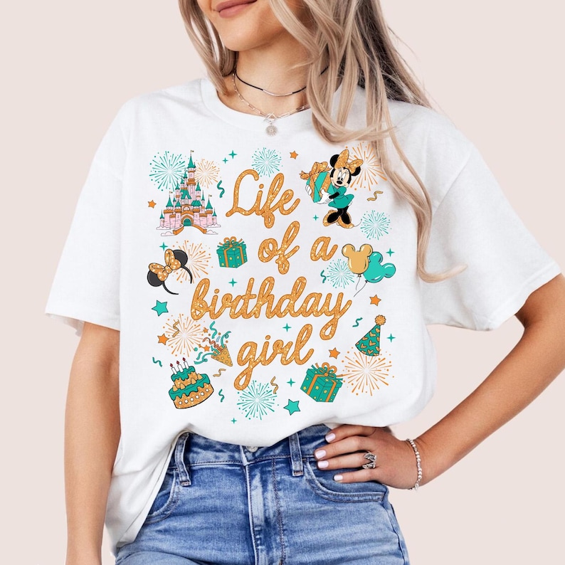 Pu&ograve; includere: T-shirt bianca con una grafica colorata che recita "Life of a birthday girl". Il design include un castello, Minnie Mouse, regali, fuochi d'artificio e una torta di compleanno. Un capo casual per tutti i giorni.