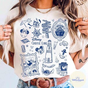 Peut inclure: T-shirt cr&egrave;me avec un motif bleu Disney Cruise Line. Le graphisme comprend divers &eacute;l&eacute;ments nautiques comme un navire, un phare, une ancre et des personnages de dessins anim&eacute;s. Le t-shirt a un col rond et des manches courtes.