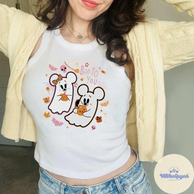 May include: White tank top with a Halloween-themed graphic. The design features two cartoon ghost mice holding pumpkins, with the text "Boo To You" in pink and orange. Bats, stars, and pumpkins complete the festive design.