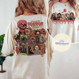 Puede incluir: Camiseta color crema con un dise&ntilde;o de Halloween Horror Nights. El gr&aacute;fico trasero incluye una calavera roja, televisores vintage con personajes de terror y el texto "Halloween Horror Nights". La parte delantera tiene un grupo de figuras de terror y un globo rojo.