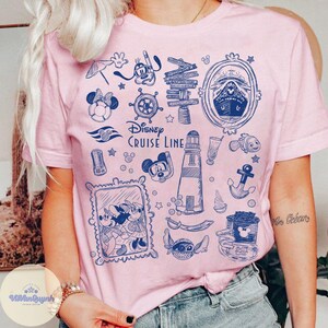 Peut inclure: T-shirt rose clair avec un motif bleu Disney Cruise Line. Le motif comprend des illustrations de Mickey et Minnie Mouse, un bateau de croisi&egrave;re, un phare, une ancre et des &eacute;l&eacute;ments nautiques. Le t-shirt a un col rond et des manches courtes.