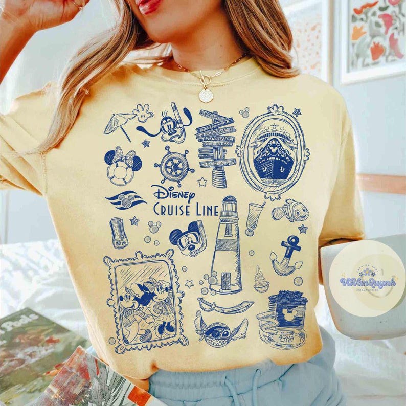 Peut inclure: T-shirt jaune clair avec un motif bleu Disney Cruise Line. Le motif comprend Mickey et Minnie Mouse, un bateau de croisi&egrave;re, un phare et des symboles nautiques. Le t-shirt a un col rond et des manches courtes.