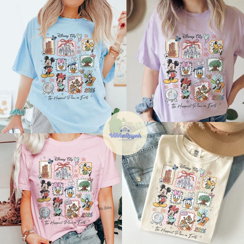 K&ouml;nnte beinhalten: Vier kurz&auml;rmelige T-Shirts in Pastellfarben: Hellblau, Lavendel, Rosa und Creme. Jedes Shirt zeigt eine farbenfrohe Grafik mit Disney-Figuren, Briefmarken und dem Text "Disney Trip 2026" und "The Happiest Place on Earth."