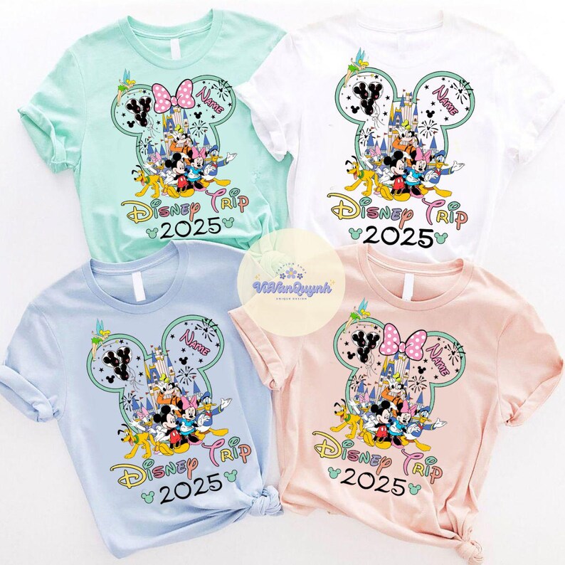 May include: Four short-sleeved t-shirts in pastel colors: mint green, white, light blue, and pink. Each shirt features a Mickey Mouse head design with Disney characters, a castle, fireworks, and the text "Disney Trip 2025".