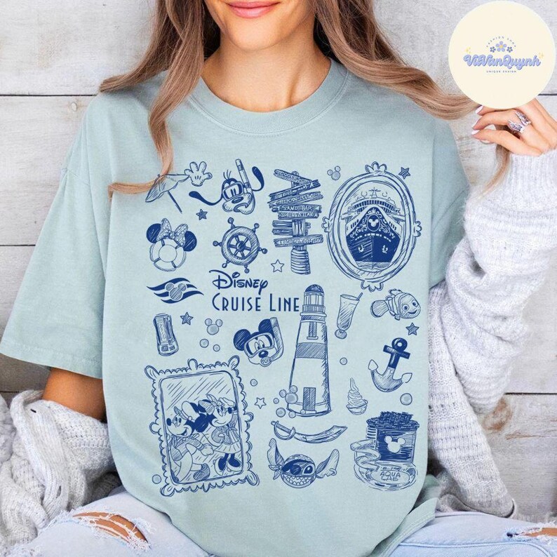 Peut inclure: T-shirt bleu clair avec un motif bleu sur le th&egrave;me de Disney Cruise Line. Le design comprend Mickey Mouse, Minnie Mouse, un bateau de croisi&egrave;re, un phare et d'autres &eacute;l&eacute;ments nautiques. Le texte "Disney Cruise Line" est &eacute;galement imprim&eacute;.