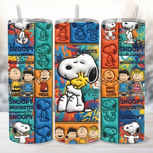 May include: Three stainless steel tumblers featuring a colorful design with Snoopy, Woodstock, and other Peanuts characters. The design includes the words "Snoopy" and "Woodstock" in a block pattern with a straw.