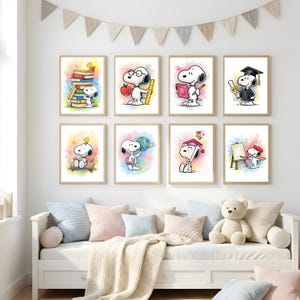 Könnte beinhalten: Ein Set von acht gerahmten Snoopy-Kunstdrucken. Jeder Druck zeigt Snoopy in verschiedenen akademischen und künstlerischen Umgebungen, wie beim Lesen von Büchern oder mit einer Abschlusskappe. Die Drucke haben einen Aquarellstil mit farbenfrohen Hintergründen und werden über einem weißen Sofa präsentiert.