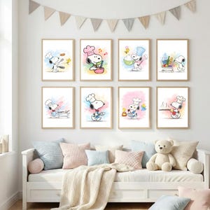 Könnte beinhalten: Acht gerahmte Snoopy-Kunstdrucke. Jeder Druck zeigt Snoopy mit Kochmütze bei verschiedenen Kochaktivitäten. Die Drucke haben einen Aquarellhintergrund in Pastellfarben. Die Kunstwerke werden über einem weißen Sofa mit Kissen und einem Teddybären ausgestellt.