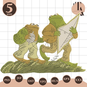 May include: An embroidered design featuring two anthropomorphic frogs. One frog carries a spool of thread, the other holds a kite. The frogs are dressed in tan and green clothing, walking on a green grassy surface.