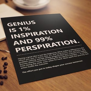 May include: A black poster with white text that reads "GENIUS IS 1% INSPIRATION AND 99% PERSPIRATION." Additional text below discusses the effort needed to achieve success. The poster is on a wooden surface with coffee beans and a notebook.