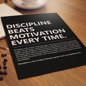 May include: A black poster with the text "DISCIPLINE BEATS MOTIVATION EVERY TIME" in white. The poster is on a wooden surface with coffee beans and a notebook. The poster also has a paragraph of text.
