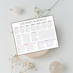 May include: A printed cleaning schedule with a pastel color scheme. The schedule is divided into daily, weekly, monthly, and quarterly tasks. The title "CLEANING SCHEDULE" is at the top. The schedule is on a beige plate with decorative flowers and orbs.