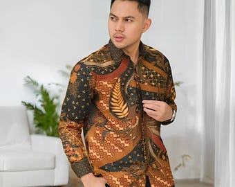 May include: A long-sleeved button-down shirt with a batik pattern in shades of brown, black, and orange. The shirt features a detailed floral and geometric design. The image includes the text "JitoArt" in the bottom right corner.