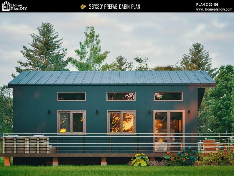 May include: A dark green prefab cabin plan measuring 26'x30' with a metal roof, horizontal siding, and a front deck featuring a metal railing. The structure includes three upper transom windows, two lower windows, and a glass door with light wood frames.