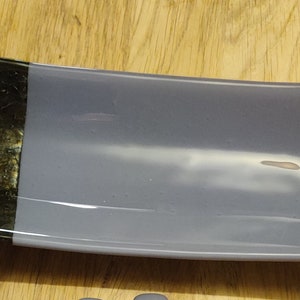 Könnte beinhalten: Eine graue Glasservierplatte mit einem schwarzen Streifen in der Mitte.