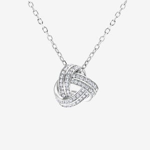 May include: A silver necklace with a knot-shaped pendant encrusted with clear cubic zirconia stones.