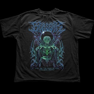 May include: Black t-shirt with a detailed graphic of a skeletal figure in green and blue. The design includes the text "IS IT LIKE THE HAND OF GOD HOVERING ABOVE?" in white. The shirt has a crew neck.