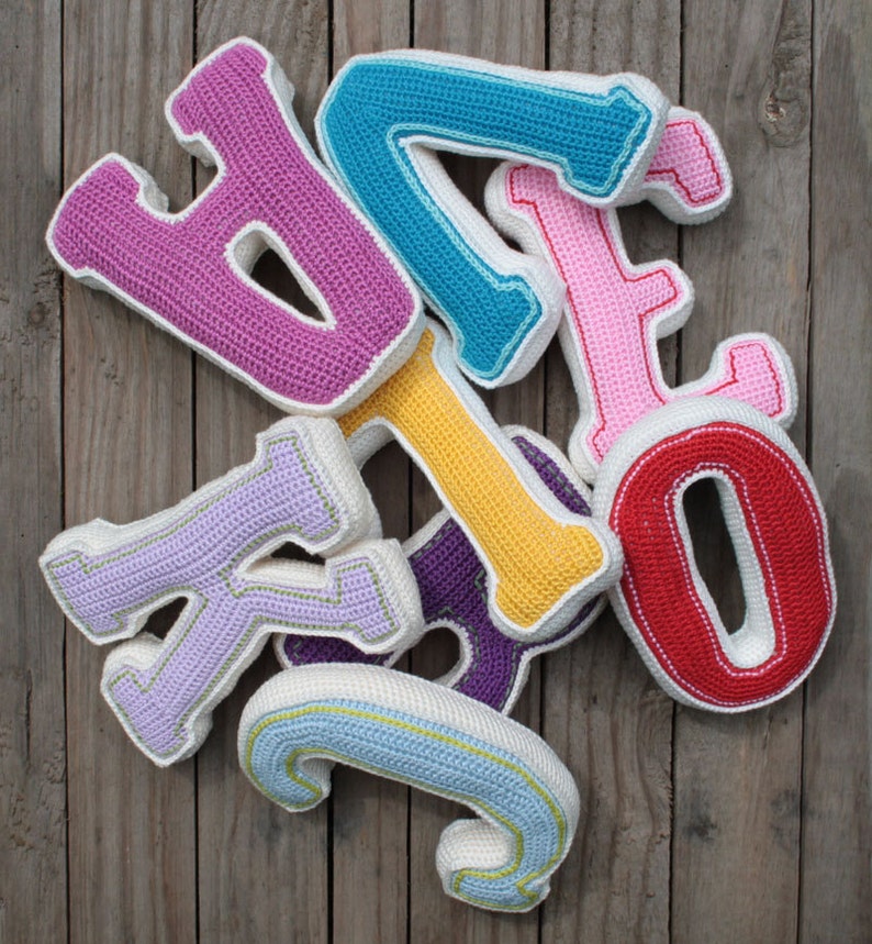 May include: A set of colorful crocheted letters, including a pink "B", a blue "I", a pink "G", a yellow "O", a purple "T", a red "O", a lavender "K", and a light blue "J".
