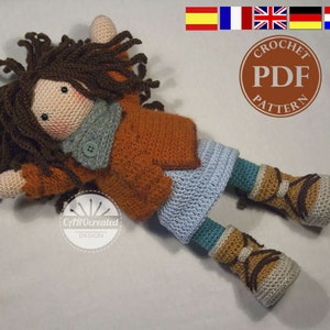 May include: Crocheted doll with brown hair, wearing a brown sweater, blue skirt, and brown boots. The doll is lying on a white surface. The image includes the text "Crochet PDF Pattern".