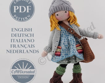 May include: Crochet doll pattern in English, German, Italian, French, and Dutch. The doll is wearing a gray cardigan, a blue and white dress, a brown bag, and a gray hat. The doll has blonde hair and brown eyes. The pattern is available as a PDF download.