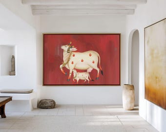 May include: A large rectangular wall art piece featuring a painting of a white cow and calf against a solid red background. The cow is adorned with gold jewellery and small red handprint motifs on its body, framed in a thin metallic gold frame.